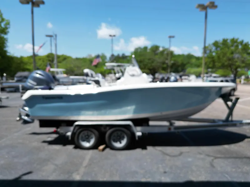 Slide: The Image of 2023 Tidewater 198CC boat on trailer in outdoor setting, slightly blurred. - 11