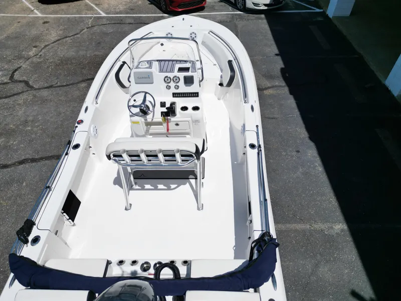 Slide: The Image of 2023 Tidewater 198CC boat interior with steering console and seating, parked on pavement. - 17