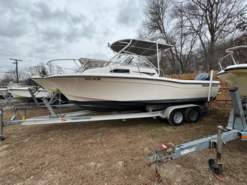 Slide: The Image of 2004 Grady-White Seafarer 228 boat on trailer, parked outdoors, overcast sky. - 0