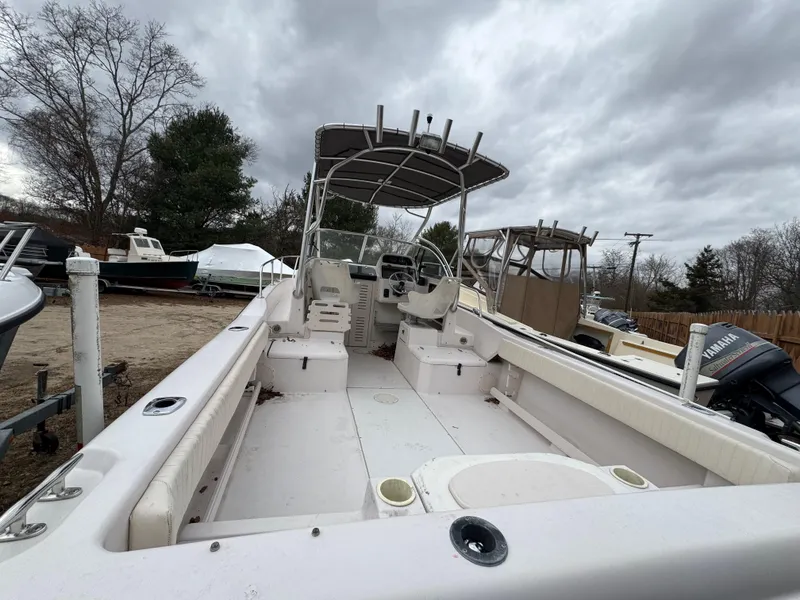 Slide: The Image of 2004 Grady-White Seafarer 228 boat with spacious deck and canopy under cloudy sky. - 8