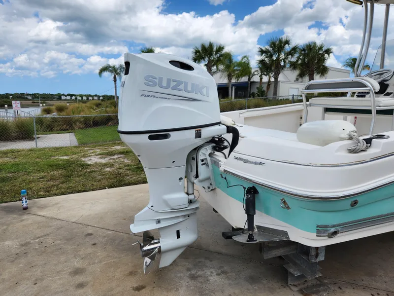 Slide: The Image of 2004 Wellcraft 200 LT Fisherman boat with Suzuki outboard motor, parked outdoors. - 10