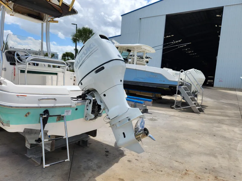 Slide: The Image of 2004 Wellcraft 200 LT Fisherman boat with outboard motor near a large storage facility. - 12