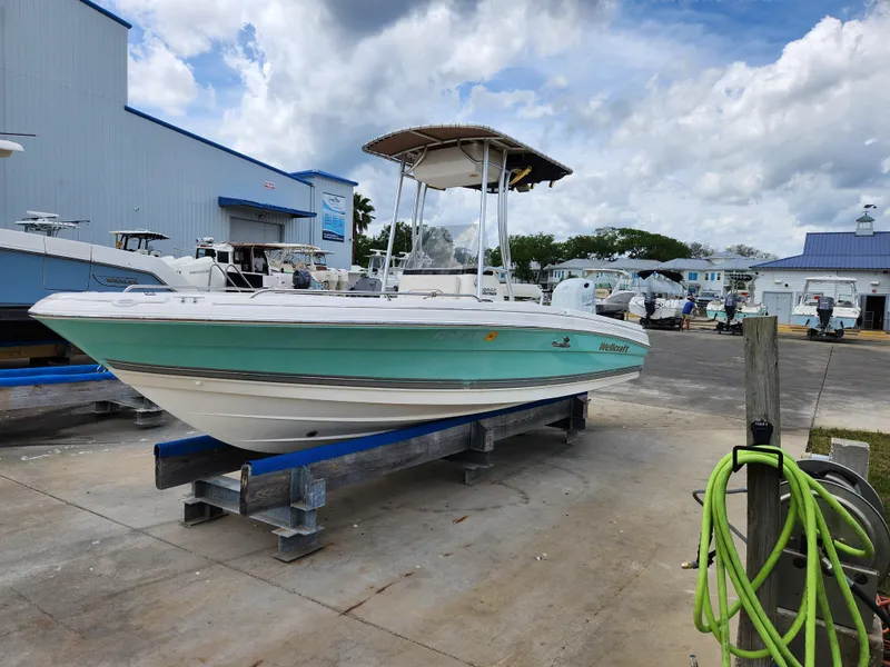 Slide: The Image of 2004 Wellcraft 200 LT Fisherman boat on a dock, under a cloudy sky. - 2