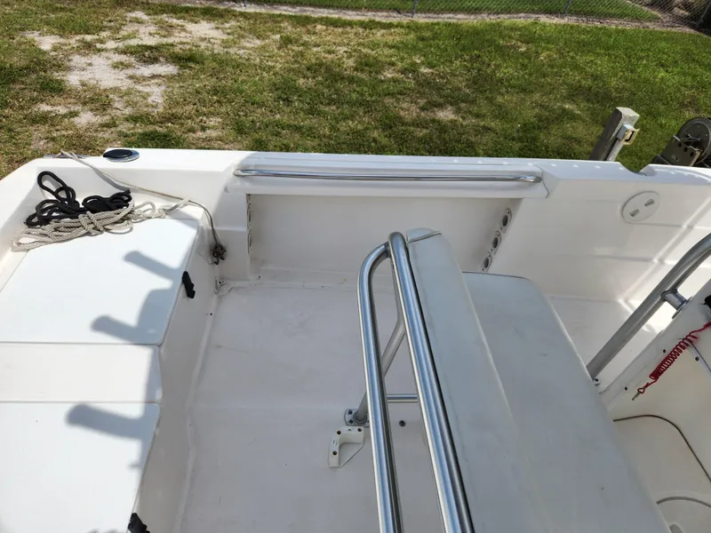 Slide: The Image of 2004 Wellcraft 200 LT Fisherman boat interior with seating and railing, docked on grass. - 24