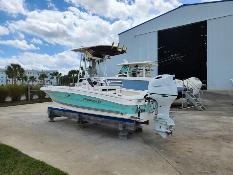 Slide: The Image of 2004 Wellcraft 200 LT Fisherman boat on display near a large storage facility. - 3