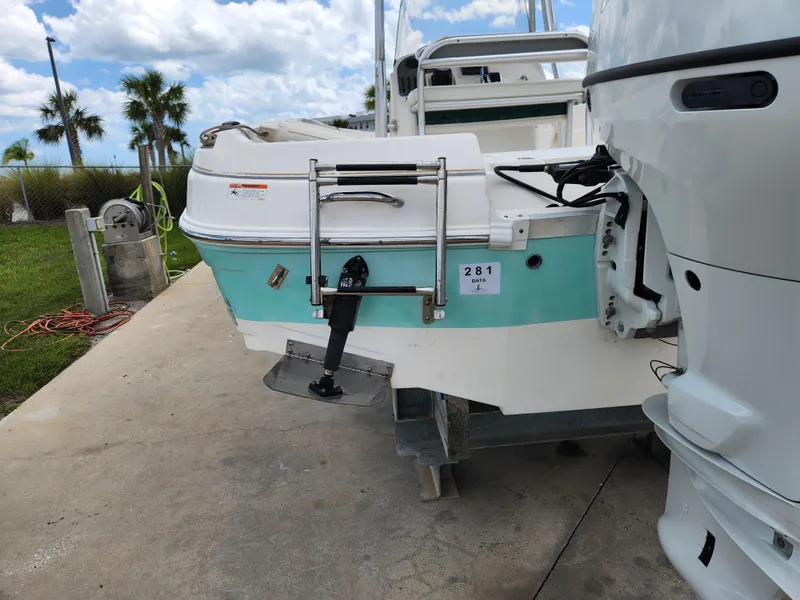 Slide: The Image of 2004 Wellcraft 200 LT Fisherman boat, docked, with outboard motor and ladder, under a partly cloudy sky. - 8