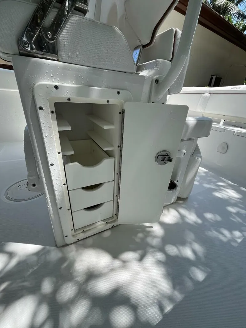 Slide: The Image of 2018 Sea Hunt 255 SE boat storage compartment with open door and interior shelves. - 11