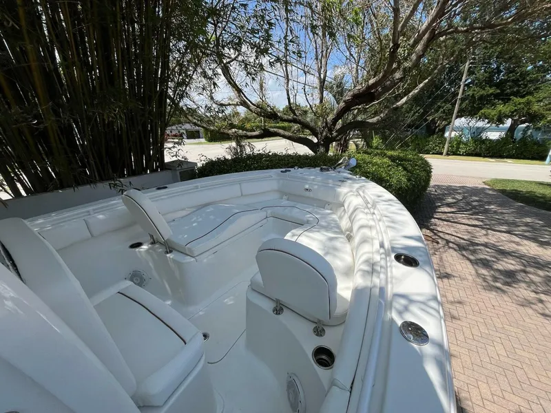 Slide: The Image of 2018 Sea Hunt 255 SE boat interior with seating, surrounded by trees and a sunny sky. - 21
