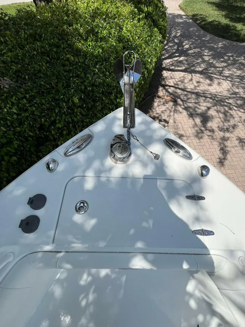Slide: The Image of 2018 Sea Hunt 255 SE boat bow with anchor, surrounded by greenery. - 23