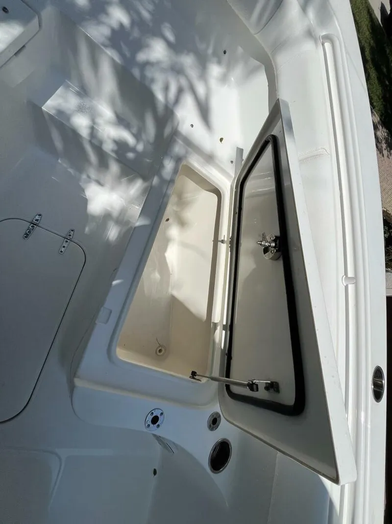 Slide: The Image of 2018 Sea Hunt 255 SE boat storage compartment open, showcasing interior space. - 24