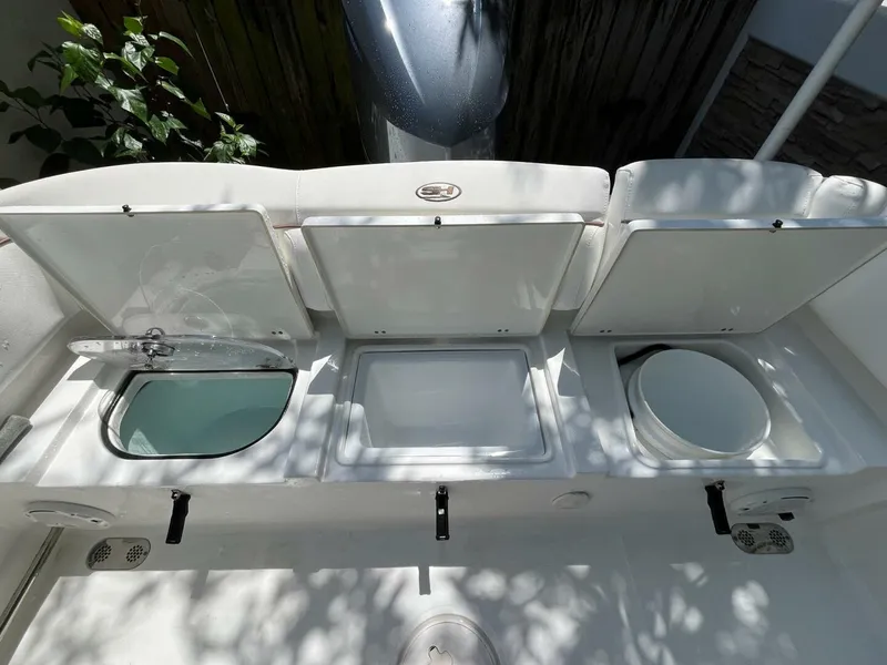 Slide: The Image of 2018 Sea Hunt 255 SE boat storage compartments with open lids, showcasing interior features. - 30
