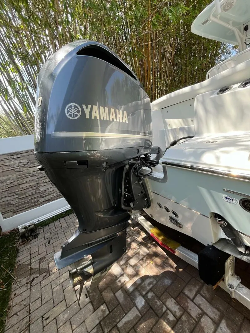 Slide: The Image of 2018 Sea Hunt 255 SE boat with Yamaha outboard motor, parked on brick pavement. - 38
