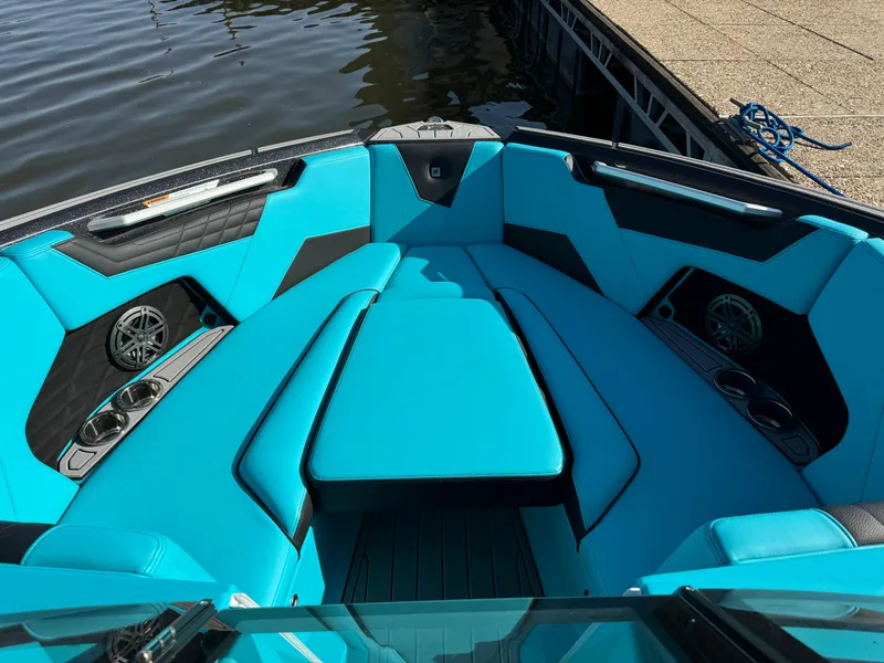Slide: The Image of 2023 Nautique Super Air Nautique S25 boat interior with vibrant blue seating and speakers. - 17