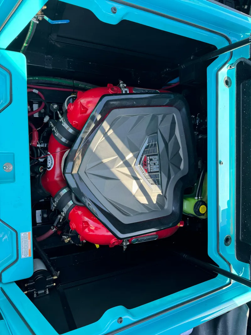 Slide: The Image of 2023 Nautique Super Air Nautique S25 engine compartment with vibrant red and blue accents. - 19