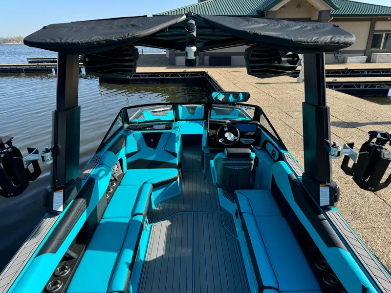 Slide: The Image of 2023 Nautique Super Air Nautique S25 boat with teal interior and black canopy. - 6