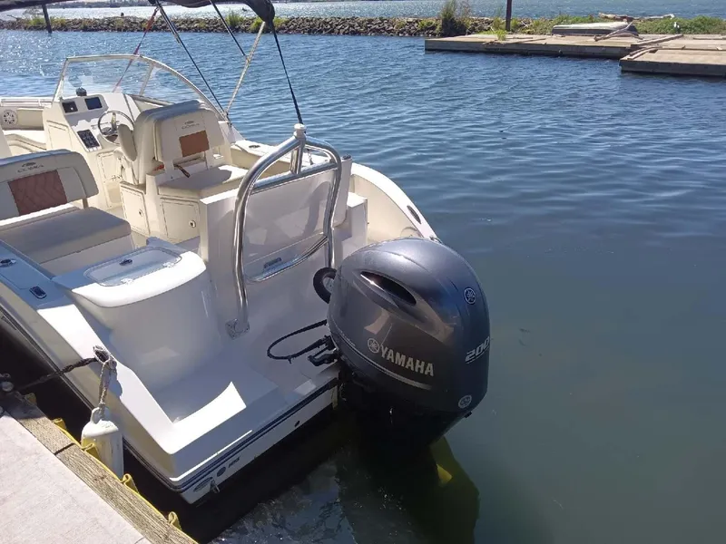 Slide: The Image of 2021 Cobia 220 Dual Console boat docked with Yamaha outboard motor. - 5