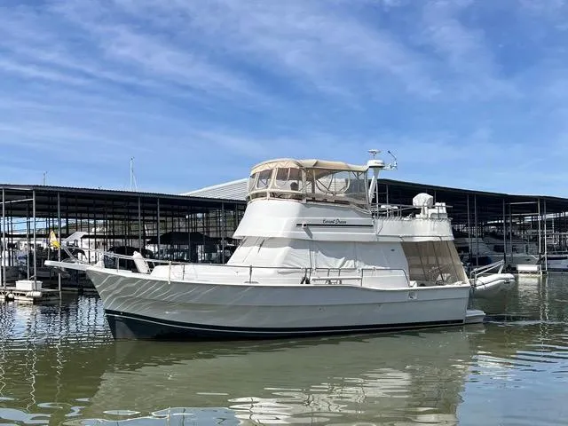 Slide: The Image of 2002 Mainship 390 Trawler docked at marina under clear blue sky. - 0