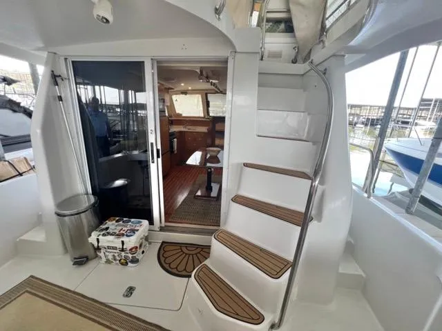Slide: The Image of 2002 Mainship 390 Trawler interior with stairs, sliding door, and nautical decor. - 10