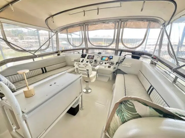 Slide: The Image of 2002 Mainship 390 Trawler helm with seating, navigation controls, and panoramic windows. - 11