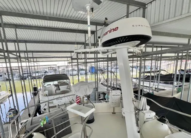 Slide: The Image of 2002 Mainship 390 Trawler in covered marina, featuring radar and navigation equipment. - 13