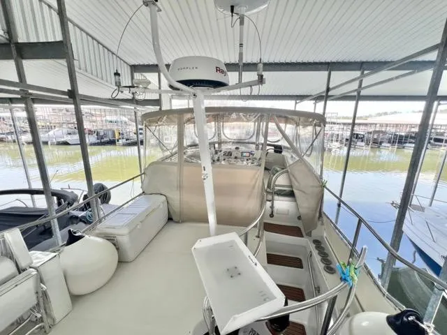 Slide: The Image of 2002 Mainship 390 Trawler interior with helm, seating, and marina view. - 14