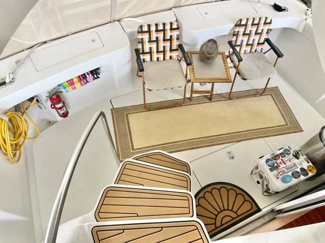 Slide: The Image of 2002 Mainship 390 Trawler interior with patterned chairs, table, and nautical decor. - 17