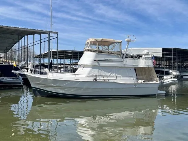 Slide: The Image of 2002 Mainship 390 Trawler docked at marina under clear blue sky. - 2