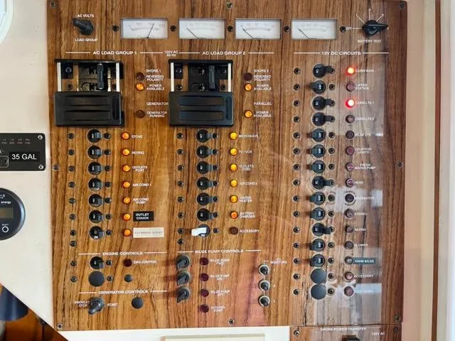Slide: The Image of Control panel of a 2002 Mainship 390 Trawler with various switches and indicators. - 21