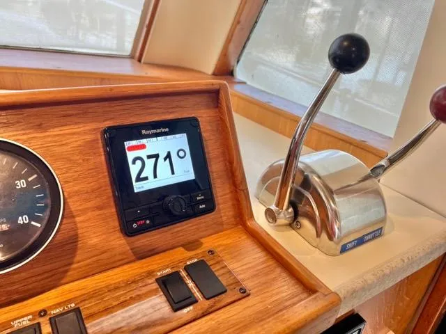 Slide: The Image of 2002 Mainship 390 Trawler helm with navigation instruments and throttle controls. - 28