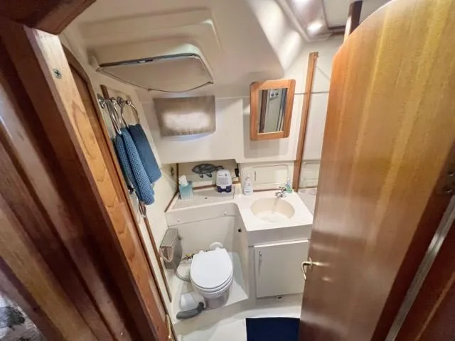 Slide: The Image of Bathroom interior of 2002 Mainship 390 Trawler with sink, toilet, and mirror. - 32