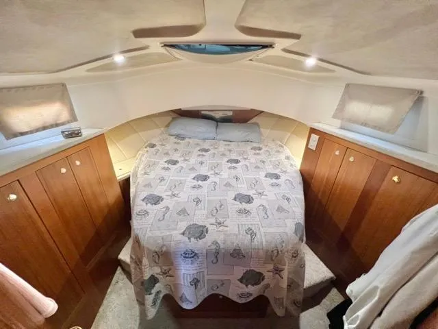 Slide: The Image of Cozy cabin interior of 2002 Mainship 390 Trawler with bed and wooden cabinetry. - 34