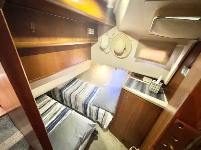 Slide: The Image of 2002 Mainship 390 Trawler cabin with twin beds, wooden cabinetry, and nautical decor. - 35