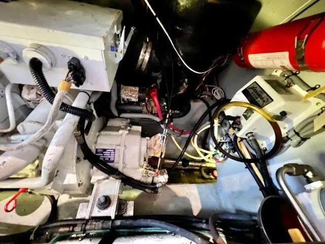 Slide: The Image of Engine room of a 2002 Mainship 390 Trawler with visible machinery and wiring. - 41