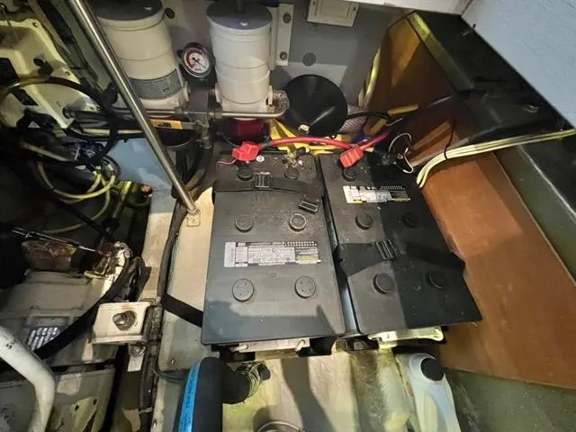 Slide: The Image of Engine room of 2002 Mainship 390 Trawler showing batteries and wiring. - 44