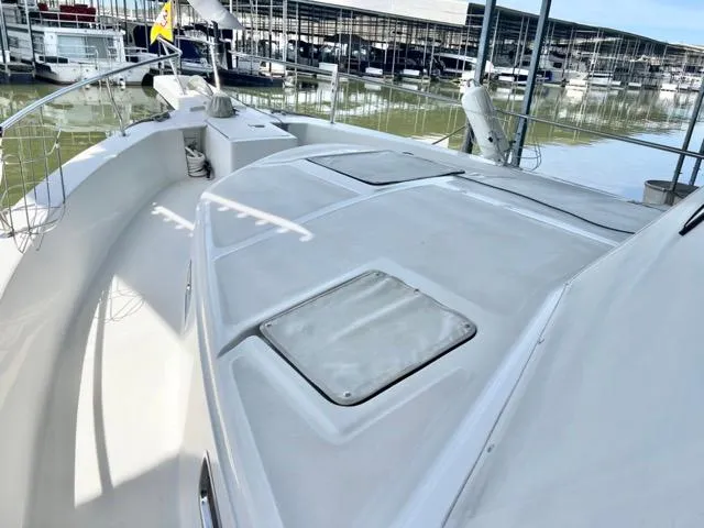 Slide: The Image of 2002 Mainship 390 Trawler deck view at marina, showcasing spacious layout and clean design. - 47