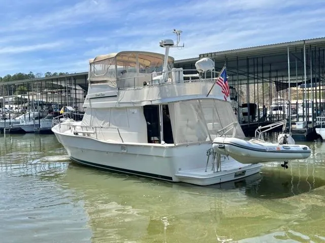 Slide: The Image of 2002 Mainship 390 Trawler docked at marina with American flag and inflatable boat. - 5