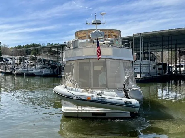 Slide: The Image of 2002 Mainship 390 Trawler docked at marina with inflatable boat attached. - 6