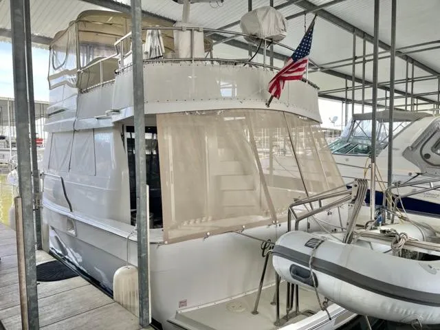 Slide: The Image of 2002 Mainship 390 Trawler docked with American flag and inflatable boat. - 7
