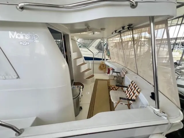 Slide: The Image of 2002 Mainship 390 Trawler, rear deck view with seating and stairs. - 9
