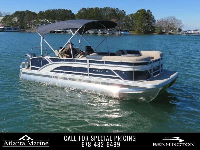 Slide: The Image of 2025 Bennington 22SSB pontoon boat cruising on a lake under clear blue skies. - 1
