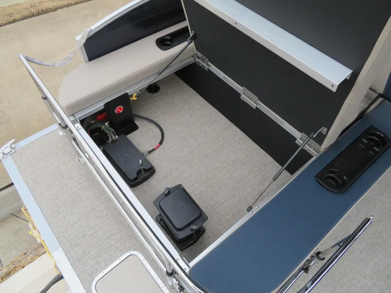 Slide: The Image of 2025 Bennington 22SSB pontoon boat interior with open storage compartment and battery setup. - 14