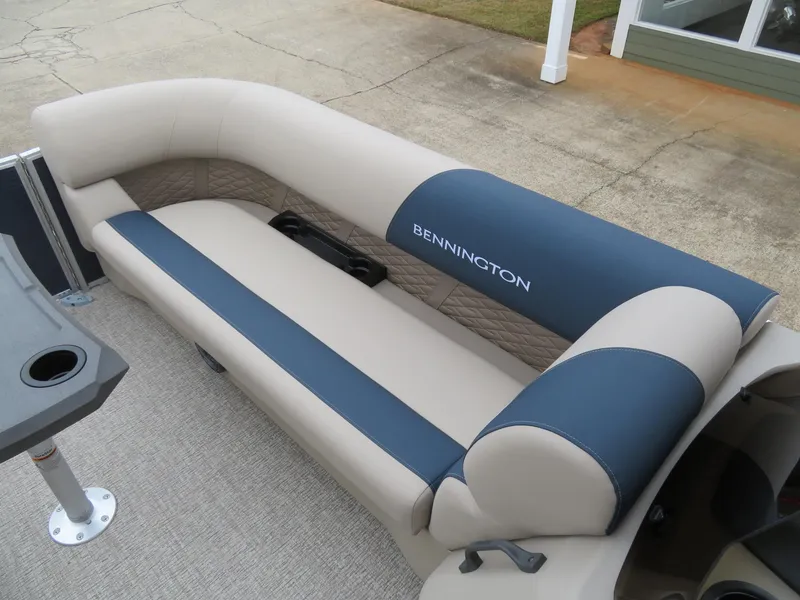 Slide: The Image of 2025 Bennington 22SSB boat seating with beige and blue upholstery, featuring a cup holder. - 18
