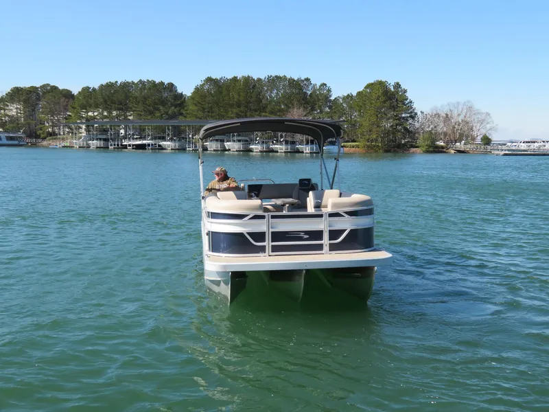 Slide: The Image of 2025 Bennington 22SSB pontoon boat cruising on a serene lake. - 24