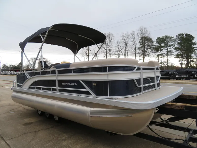 Slide: The Image of 2025 Bennington 22SSB pontoon boat with canopy, parked on a trailer. - 3