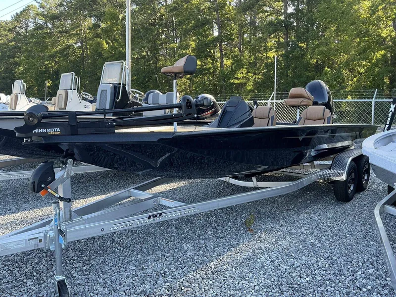 Slide: The Image of 2025 Xpress Hyper-Lift Series H20 BASS boat on trailer, parked on gravel. - 2