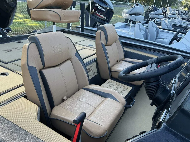 Slide: The Image of 2025 Xpress Hyper-Lift Series H20 BASS boat interior with tan seats and steering wheel. - 4