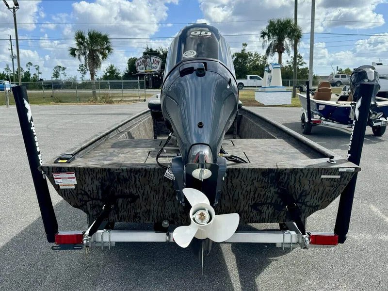 Slide: The Image of 2025 Xpress Xplorer Series XP18CC boat with powerful outboard motor, parked outdoors. - 2