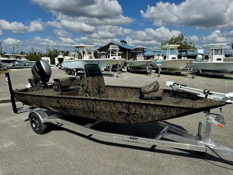 Slide: The Image of 2025 Xpress Xplorer Series XP18CC boat on trailer, surrounded by other boats, under cloudy sky. - 5