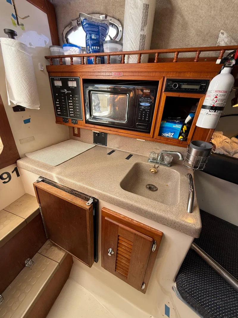 Slide: The Image of 2001 Albemarle 280 Express Sport Fisherman galley with sink, microwave, and storage cabinets. - 26