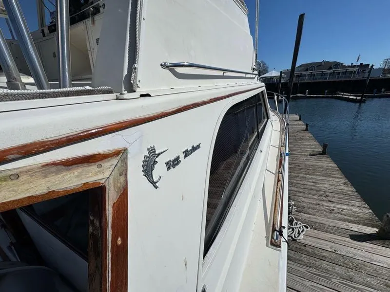 Slide: The Image of 1985 Egg Harbor 37 Convertible yacht docked at a marina, showcasing classic design. - 10